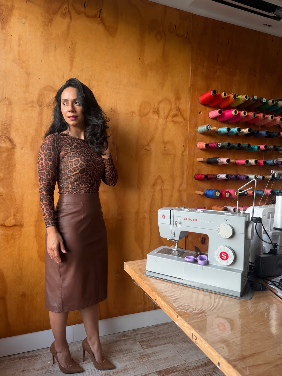 Jane Karen vestindo o conjunto Saia Reta + Blusinha ao lado da máquina de costura